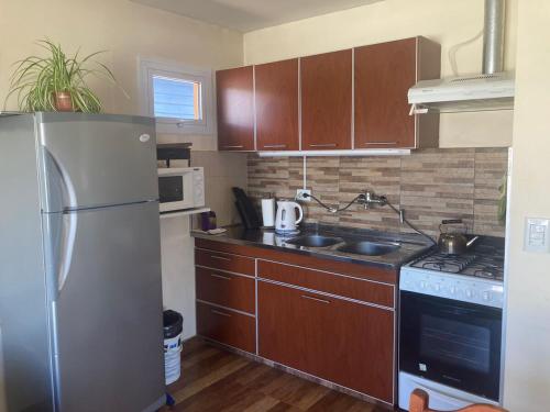 een kleine keuken met een koelkast en een fornuis bij Casa Lago Argentino in El Calafate