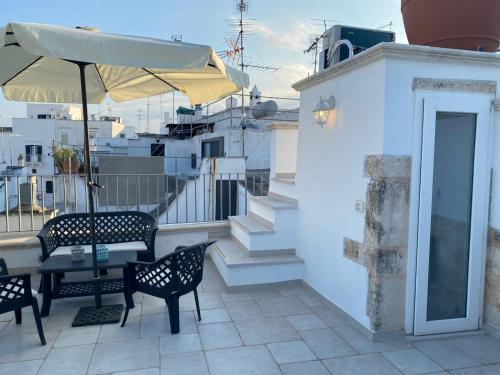 a patio with a table and chairs and an umbrella at In centro da Cinzia in Ostuni