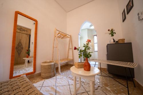 ein Zimmer mit einem Spiegel und einem Tisch mit Blumen darauf in der Unterkunft Riad Le Soleil de Bahia in Marrakesch