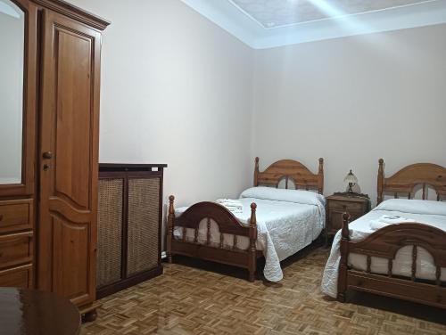 a bedroom with two beds and a dresser at Casa Turística Plaza del Conde in Ciudad-Rodrigo
