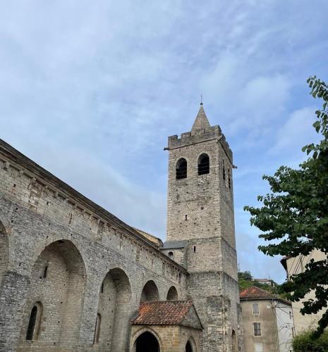 an old building with a tower on top of it at Une chambre au jardin in Saint-Pons-de-Thomières