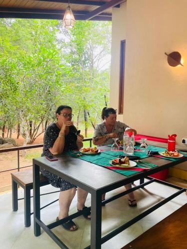 two women sitting at a table eating food at Mind Body and Soul in Dambulla