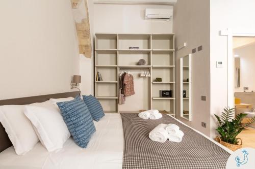 a room with a bed with towels on it at Domus Carolina - Stylish living in the soul of Cagliari in Cagliari