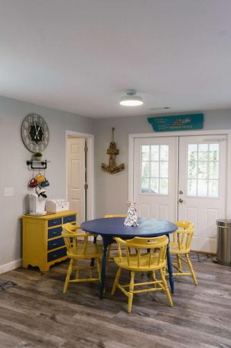 a dining room with a blue table and yellow chairs at Sailors Delight in Beaufort