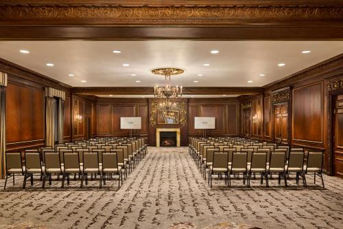 an empty room with rows of chairs and a chandelier at Boston Omni Parker House Hotel in Boston