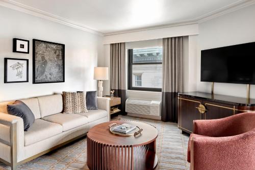 a living room with a couch and a tv at Boston Omni Parker House Hotel in Boston