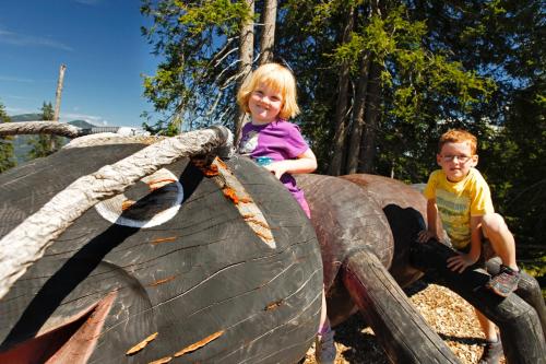 a little girl and boy sitting on an elephant playground at Reiters-Ferienhaus in Russbach am Pass Gschütt