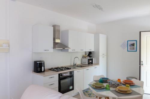 a kitchen with white cabinets and a table in it at Costa Trabocchi appartamento sul Mare in Fossacesia