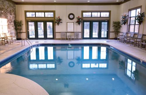 a swimming pool in a hotel with tables and chairs at Wyndham Smoky Mountains 1BR Suite with Resort Access in Pigeon Forge