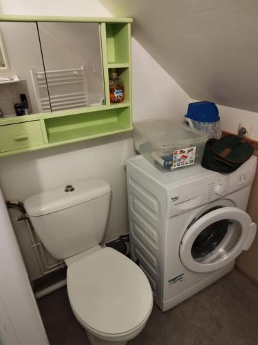 a bathroom with a toilet and a washing machine at studio des roses in Gournay-en-Bray