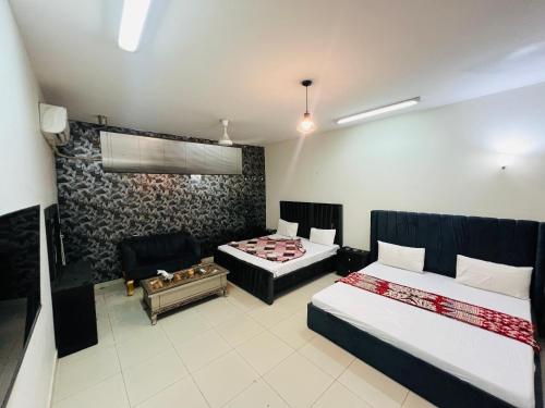 a hotel room with two beds and a couch at Islamabad Capital Lodge in Islamabad