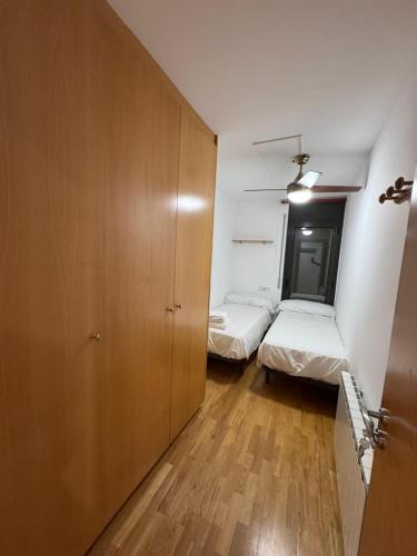 a small room with two beds and a closet at El teu habitatge a Tremp in Tremp