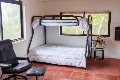 a bedroom with a bunk bed and a chair at Private luxury house 3 floors in Los Altos de Cerro Azul