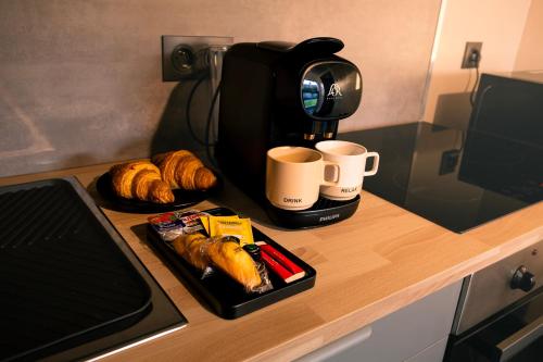 - une table avec des tasses de café et des croissants dans l'établissement TheRubyLodge, à Ourville-en-Caux