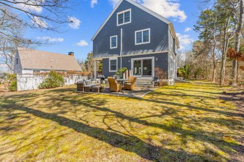 a home with a blue house with a yard at Summer by the Sea - Central to all beaches & ponds in Mashpee