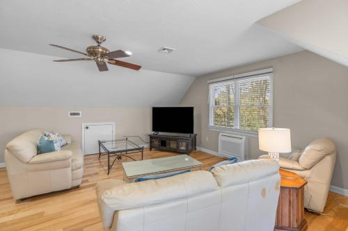 a living room with white furniture and a ceiling fan at Summer by the Sea - Central to all beaches & ponds in Mashpee