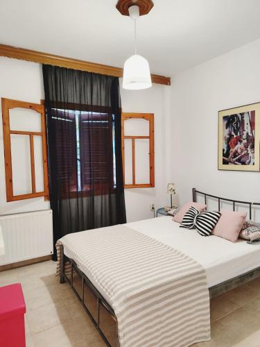 a bedroom with a large white bed with pink pillows at Isminis country house in Vergia