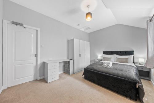 a white bedroom with a bed and a desk at Modern Bannockburn Guest House - Ensuite Rooms Only in Bannockburn