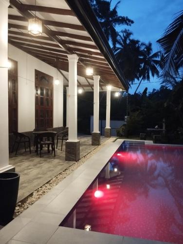 a swimming pool in the middle of a house at night at Serene Bliss Villa in Unawatuna