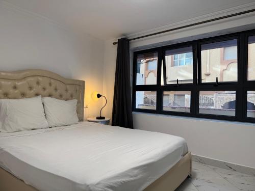 a bedroom with a white bed and a window at Appartements dior al hoceima in Al Hoceïma