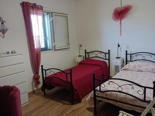 a bedroom with two beds and a window at Cirica Relax in Santa Maria Del Focallo