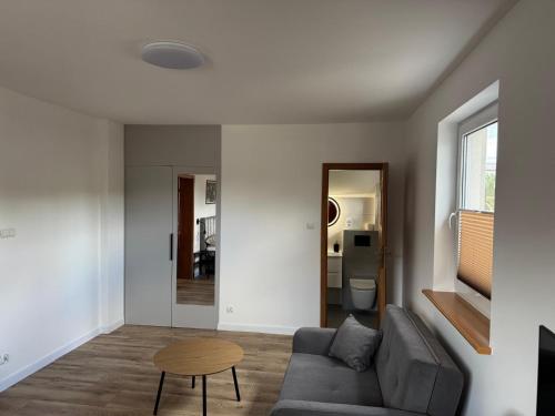 a living room with a couch and a table at Leśne Zacisze 2 in Swornegacie 