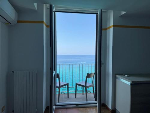 a balcony with two chairs and a view of the ocean at Harmonia Apartment with breathtaking view and a perfect location in Tropea