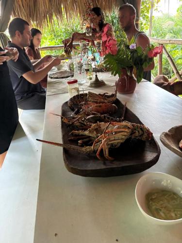 a group of people sitting at a table with a plate of food at Sea view Casita Eco Casa Algana in Caña Félix