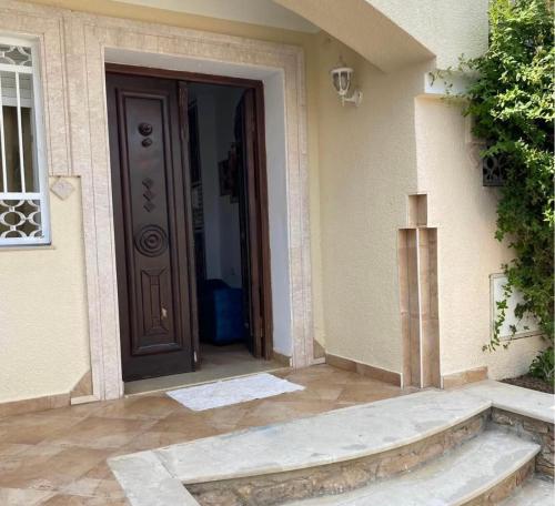 an entrance to a house with a brown door at Dar lborj in Kelibia