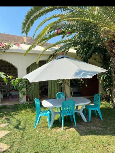 a table and chairs under an umbrella in the yard at Dar lborj in Kelibia