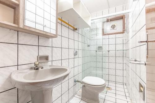 ein weißes Badezimmer mit Waschbecken und Toilette in der Unterkunft Espaçosa Casa a 200 Metros da Praia de Bombas in Bombas