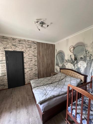 a bedroom with a bed and a brick wall at Zaritap Guest House in Zarritʼapʼ