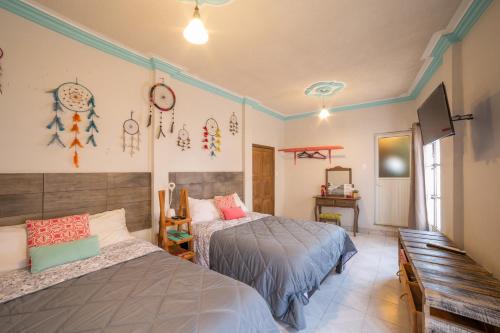 a bedroom with two beds and a bench at Casa El Ombligo de la Luna in Guanajuato