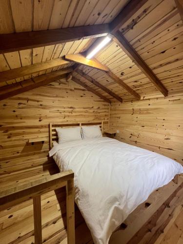 a bed in a log cabin with a ceiling at Ali's House 61 in Anayurt