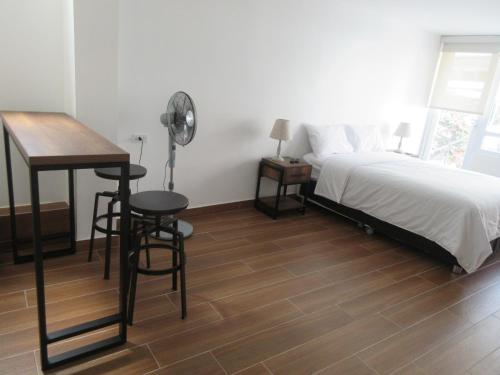 a bedroom with a bed and a desk and a table at Venue Studios in Lima