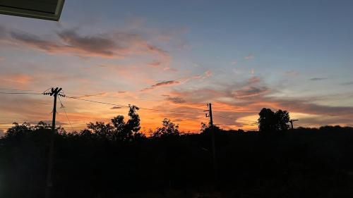 a sunset with trees and power lines in the sky at 29 Palms Thailand in Ban Klang