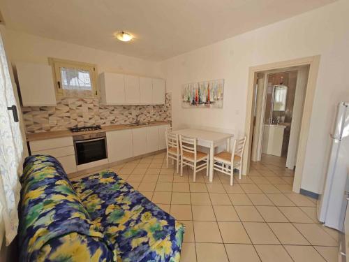 ein Wohnzimmer mit einem Sofa und eine Küche mit einem Tisch in der Unterkunft Apartments in Rosolina Mare 48309 in Rosolina Mare