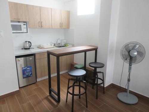 a kitchen with a counter and stools and a fan at Venue Studios in Lima