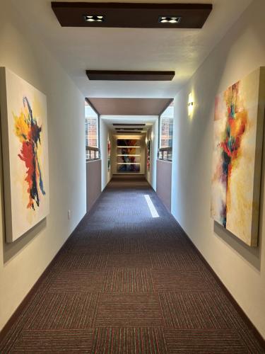a hallway in a building with paintings on the walls at Hotel El Salvador in Mexico City