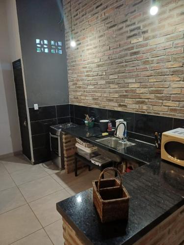a kitchen with a sink and a brick wall at Areia Green in Areia