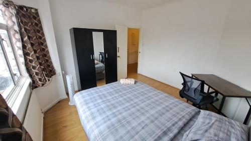 a bedroom with a bed and a desk and a window at Guest house in Dagenham East by Fenia in Dagenham