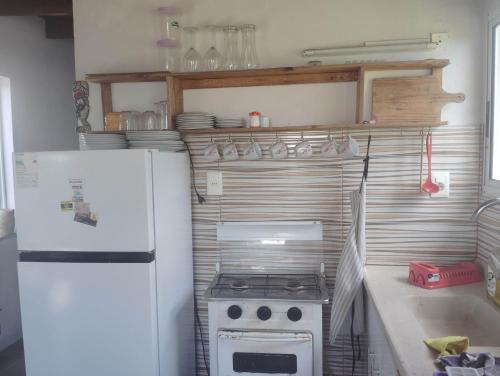 una piccola cucina con fornelli e frigorifero di emsubida a La Paloma