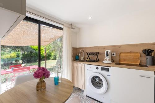 a laundry room with a washer and dryer and a window at Les Mappias en Ardèche in Vesseaux