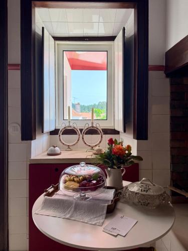 a table with a plate of food on it under a window at Casa do Pátio, casaspensadas in Juncal