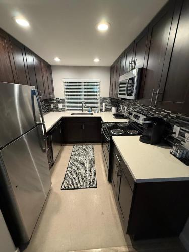 a large kitchen with wooden cabinets and stainless steel appliances at Queen Anne Retreat - 3BR Haven in the heart of Seattle in Seattle