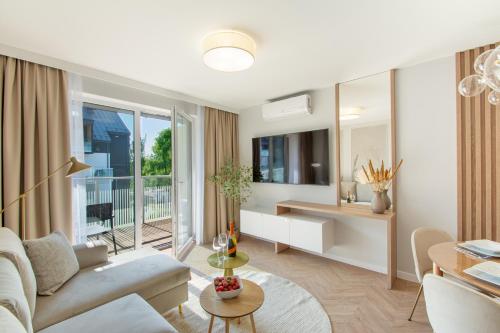a living room with a couch and a table at Klif Apartamenty Posesja Plażowa in Grzybowo