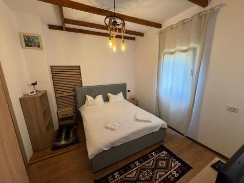 Un dormitorio con una cama y una lámpara de araña. en Casa Olivia, en Buşteni