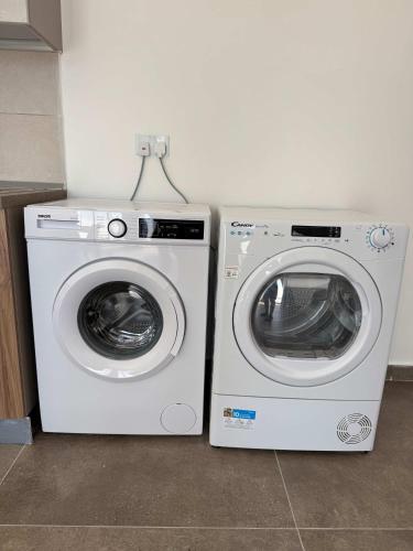 two washing machines sitting next to each other in a room at Penthouse Bliss Stylish 1B in Taʼ Penza