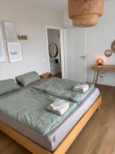 a bed with two towels on it in a bedroom at Penthouse Apartment in Gießen
