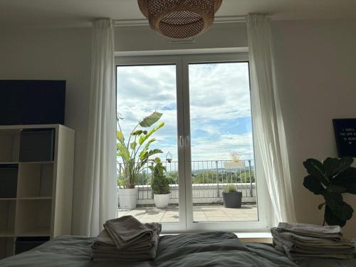 a bedroom with a bed and a large window at Penthouse Apartment in Gießen
